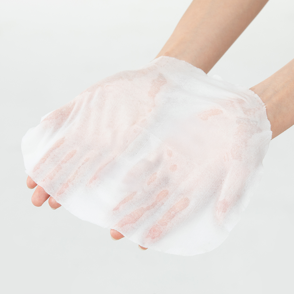 Hands holding the Skin Load Vegan Belly Mask Sheet, a serum-soaked sheet mask shaped for a pregnant belly